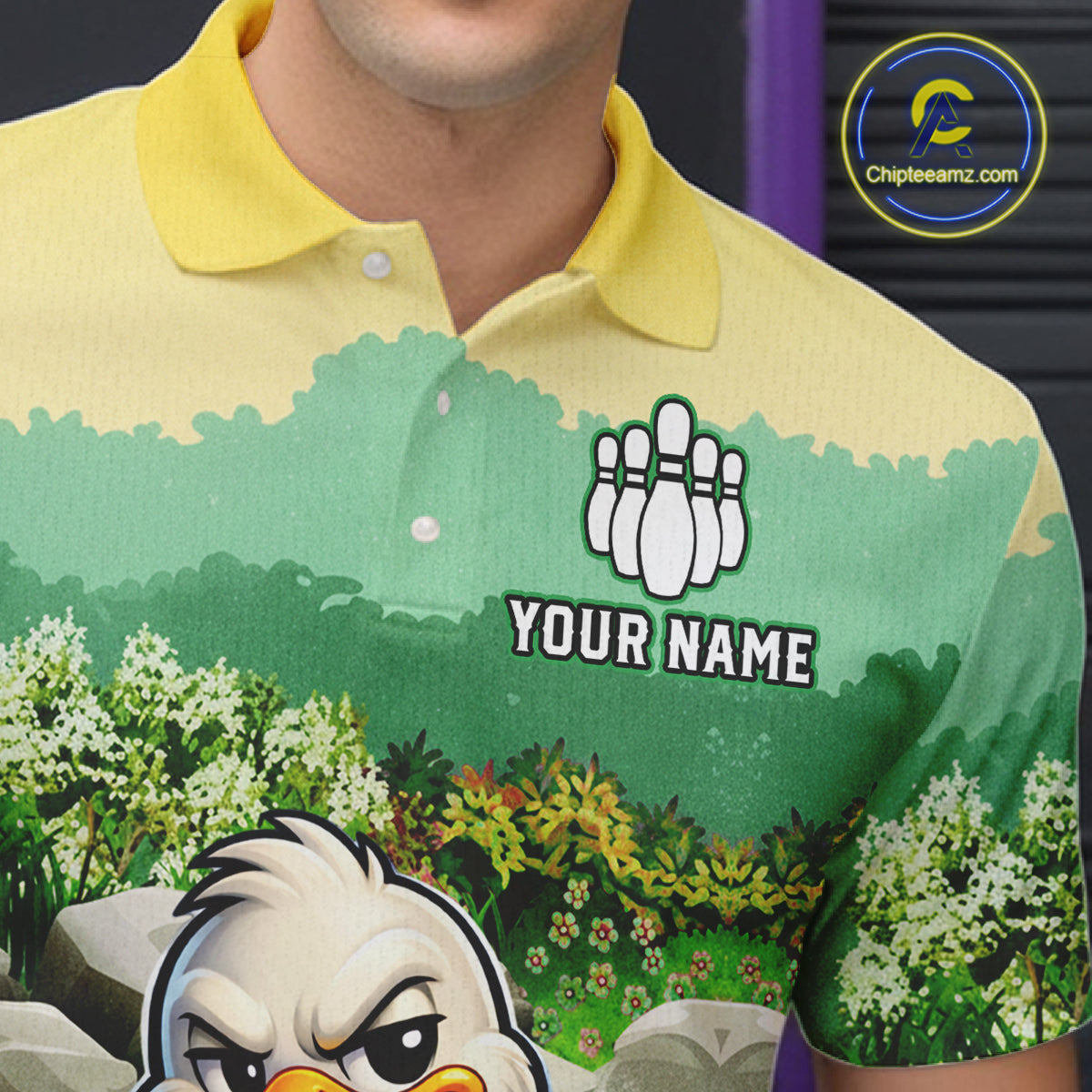 Green and yellow polo shirt with a cartoon character and customizable text on a blurred background