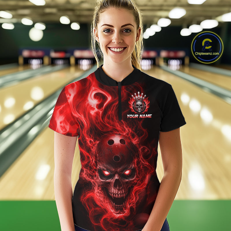 Woman wearing a black bowling quarter zip shirt featuring a flaming skull with glowing red eyes, red smoke effects, and custom “YOUR NAME” text