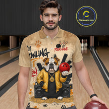 Load image into Gallery viewer, A man wearing a beige short-sleeve polo shirt with a detailed bowling-themed graphic print featuring an bulldog, bowling pins, and a red bowling ball. The background shows bowling lanes, and a 'Chipleamz.