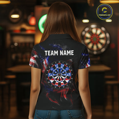 Person wearing a black darts polo featuring patriotic American flag smoke graphics, dartboards, blue darts, and custom team and player name text.