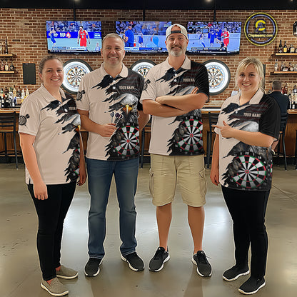 Four people wearing a beige and black darts polo featuring a bald eagle, torn-flag graphics, dartboard designs, and custom team text.