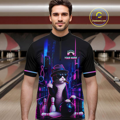 A man wearing a black short-sleeve bowling-themed quarter-zip shirt with a colorful neon cat graphic, standing in a bowling alley. The shirt features a black and white cat wearing a hat and sunglasses, holding bowling pins and a bowling ball, with the text 'YOUR NAME' and bowling pins above.