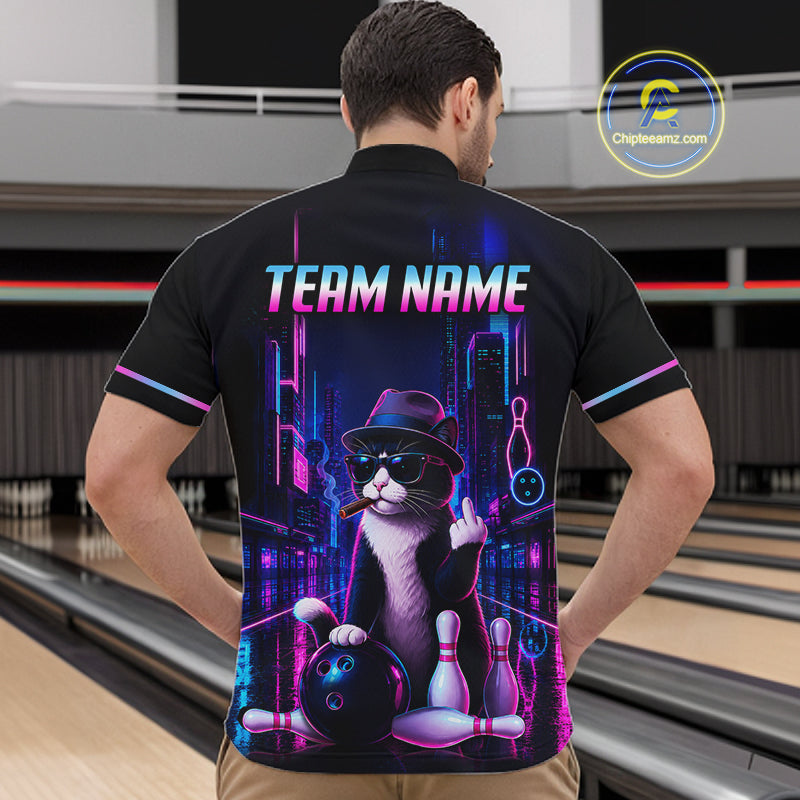 A man wearing a black short-sleeve bowling-themed quarter-zip shirt with a colorful neon cat graphic, standing in a bowling alley. The shirt features a black and white cat wearing a hat and sunglasses, holding bowling pins and a bowling ball, with the text 'TEAM NAME' and bowling pins above.