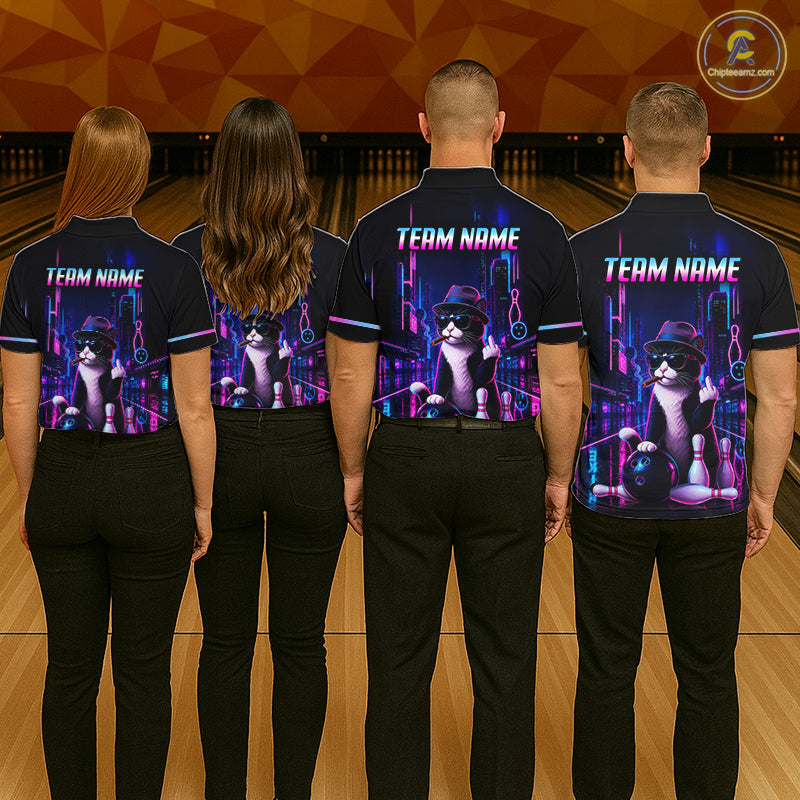 Four people standing from the back in a bowling alley, wearing matching dark navy polo shirts with a large graphic print of a cat playing bowling and the text 'TEAM NAME' on the back.