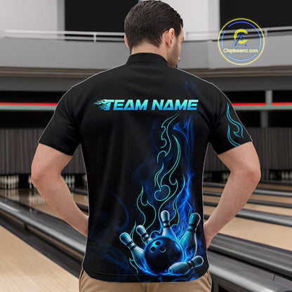 A man viewed from behind wearing a black short-sleeve bowling shirt with a large blue and cyan flame-and-bowling-ball graphic on the back, standing in a bowling alley. The shirt has 'TEAM NAME' printed across the upper back, and a circular 'ChipteeAmz.