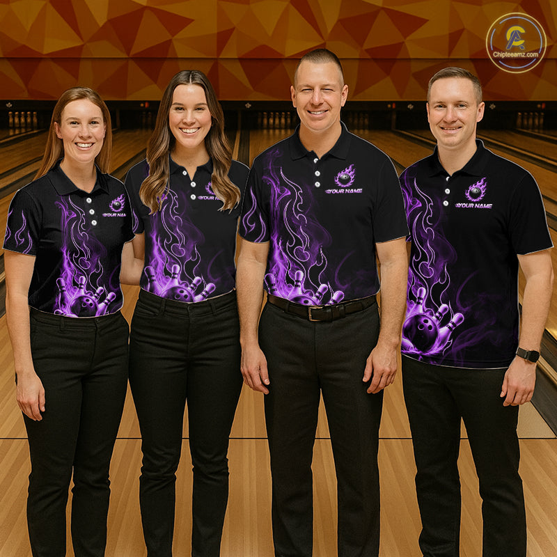 Four people standing in a bowling alley wearing matching black short-sleeve polo shirts with purple flame and bowling-pin graphics, paired with black pants. The shirts have a small white logo