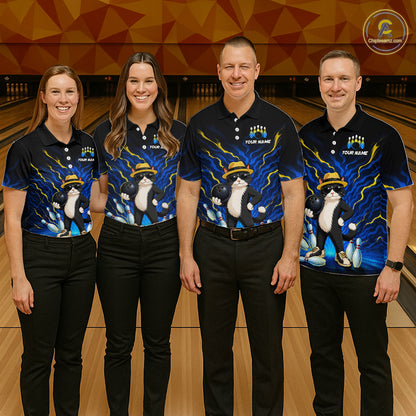 Four people standing together in a bowling alley wearing matching black short-sleeve bowling shirts with a blue and yellow lightning design and a cartoon cat wearing a bowler hat. The shirts also have placeholder text and a circular logo in the top right corner.