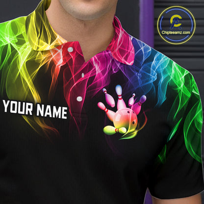 A close-up of a person wearing a black short-sleeve polo shirt with a vibrant rainbow smoke graphic and a bowling pin hand graphic on the chest. The shirt also features the text 'YOUR NAME' on the left chest and a circular 'Chipteeamz.