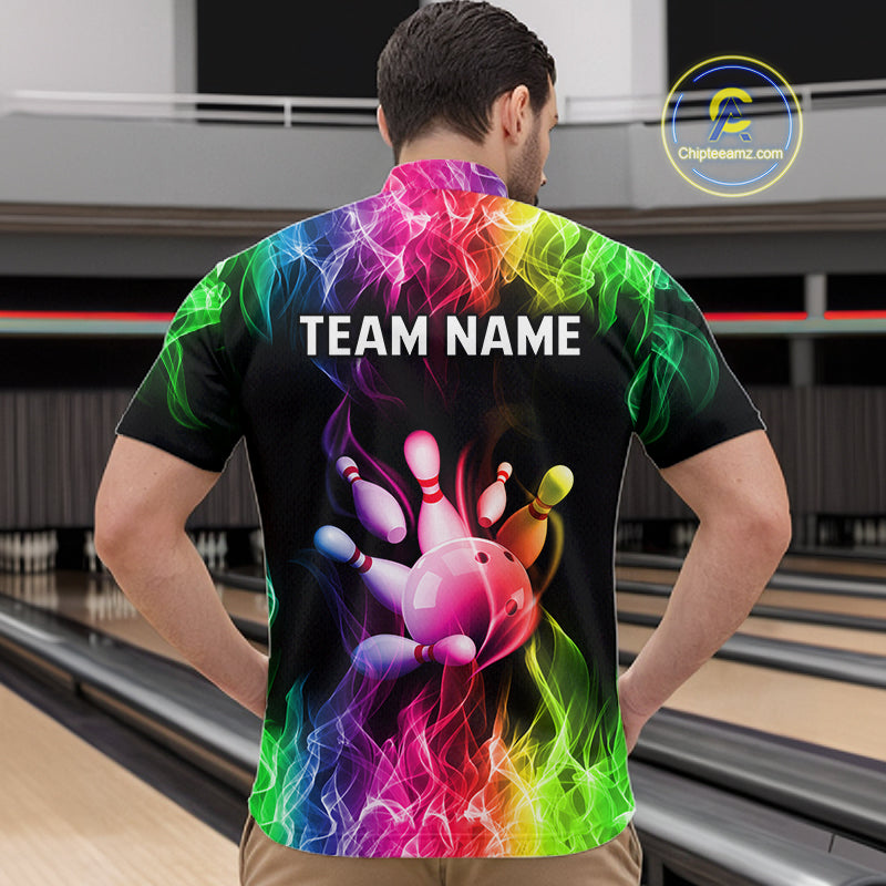 A man viewed from behind wearing a black short-sleeve bowling shirt with a vibrant multicolor rainbow flame graphic and a bowling pin/ball design on the back. The shirt features the customizable text 'TEAM NAME' in white.