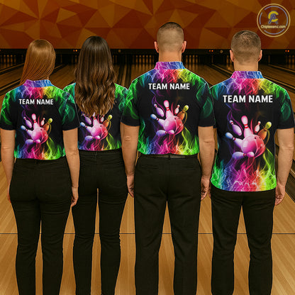 Four people standing in a bowling alley, viewed from behind, wearing matching black short-sleeve shirts with a vivid multicolor flame-and-paw print and white 'TEAM NAME' text on the back.