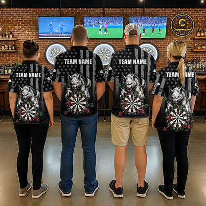 Four people standing with their backs to the camera in a bar setting, wearing matching black short-sleeve shirts with a large graphic of a wolf, dartboard, and American flag design, along with customizable text 'TEAM NAME' on the back.