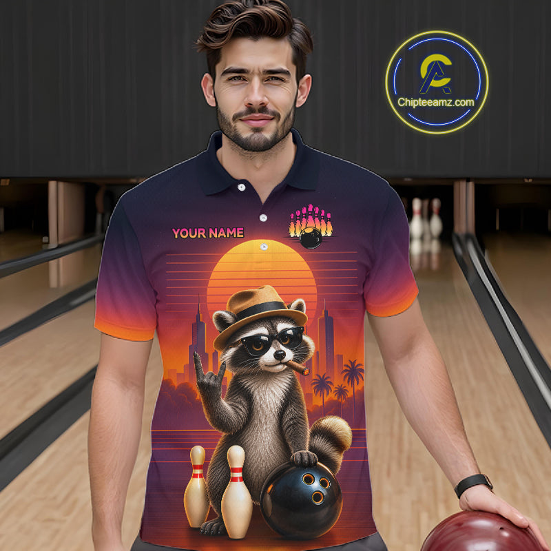 A man wearing a dark navy-to-orange gradient polo shirt with a large bowling-themed raccoon graphic on the front, standing in a bowling alley holding a bowling ball. A circular 'Chipteeamz.