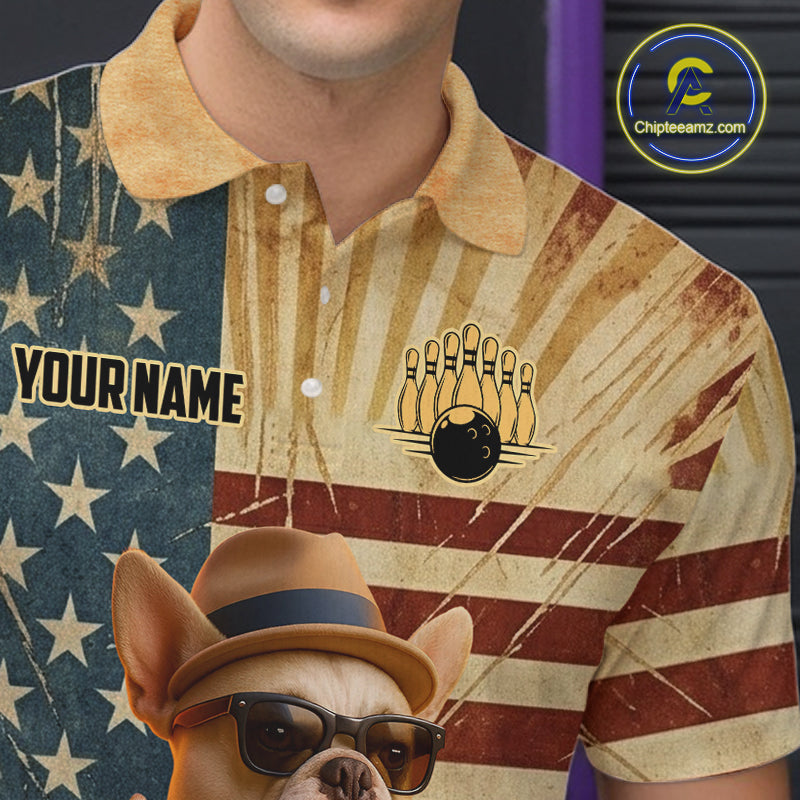 A close-up of a person wearing a short-sleeve polo shirt with a distressed American flag design, featuring a bowling pin and ball graphic on the chest and a cartoon dog wearing a hat and sunglasses near the bottom. The shirt has a yellow collar and the text 'YOUR NAME' on the left chest.