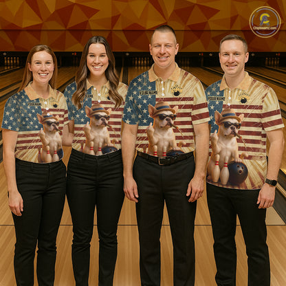 Four people standing in a bowling alley wearing matching bowling shirts with a patriotic American flag design and a printed image of a small dog wearing sunglasses. The shirts have a beige and blue color scheme with red accents.