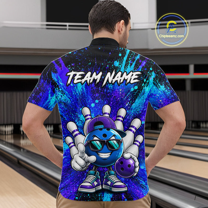 A man viewed from behind wearing a short-sleeve bowling-themed polo shirt with a colorful blue, purple, and black splatter design, a cartoon bowling ball character, and the text 'TEAM NAME' across the back. The background shows bowling lanes in a real indoor bowling alley.