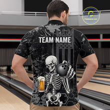 Load image into Gallery viewer, A man viewed from behind wearing a black short-sleeve bowling shirt with a large graphic of a skeleton holding a bowling ball and a beer mug, with 'TEAM NAME' printed across the back. The shirt is shown in a bowling alley setting.
