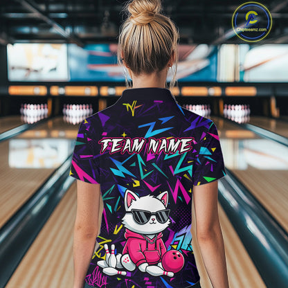 Woman wearing a black bowling quarter zip with neon geometric patterns, custom team text, and a white cat mascot in sunglasses holding a pink bowling ball.