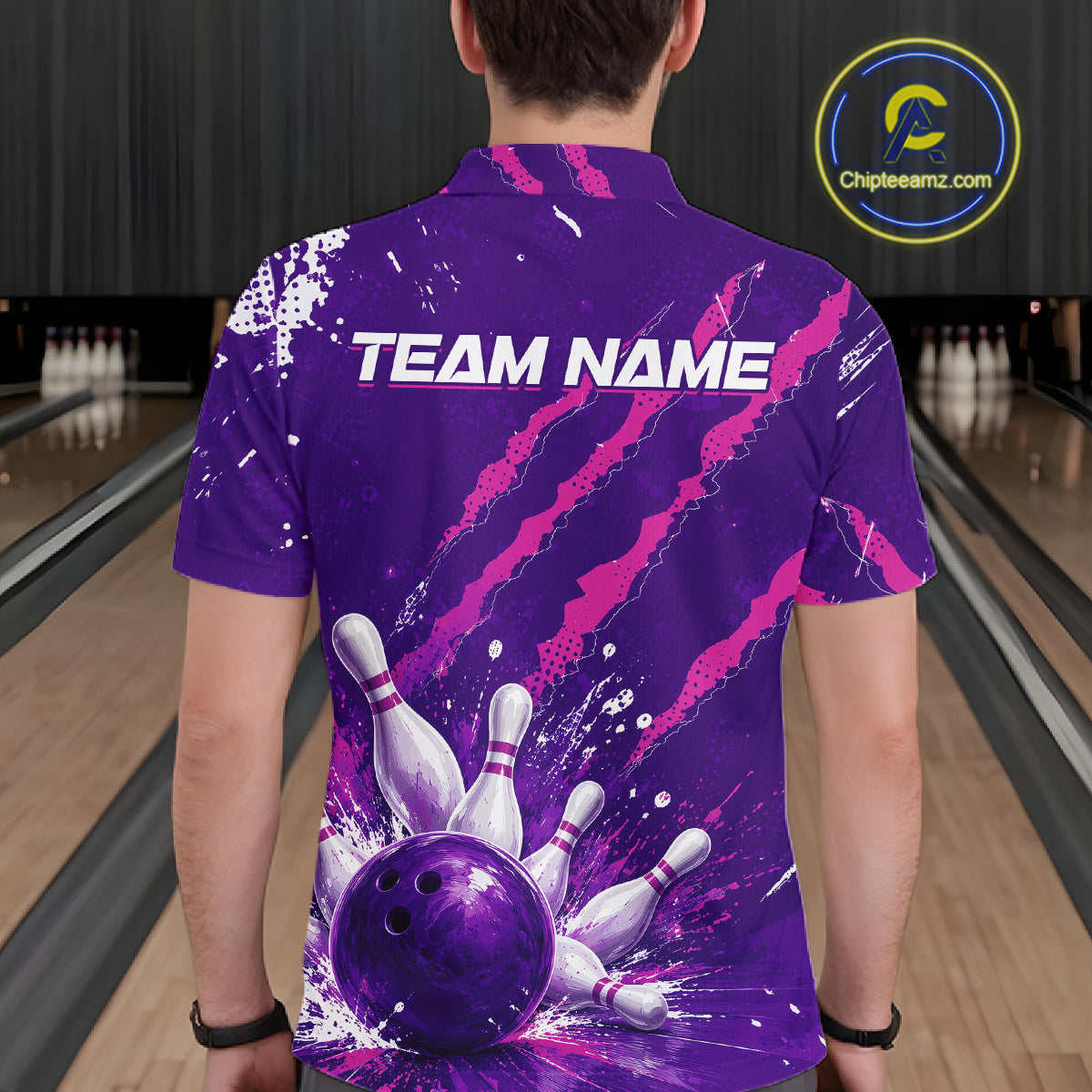 A man viewed from behind wearing a purple bowling-themed short-sleeve polo shirt with a custom 'TEAM NAME' print and bowling pins/ball graphic. The background shows bowling lanes.