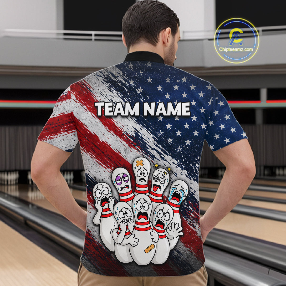 A man viewed from behind wearing a bowling-themed short-sleeve shirt with a distressed American flag design and cartoon bowling pins on the back. The shirt has 'TEAM NAME' printed across the upper back.