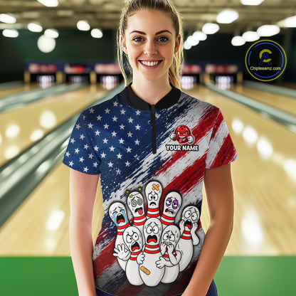 A woman stands in a bowling alley wearing a short-sleeve collared bowling shirt with a patriotic American flag design, cartoon bowling pins, and a customizable name patch.