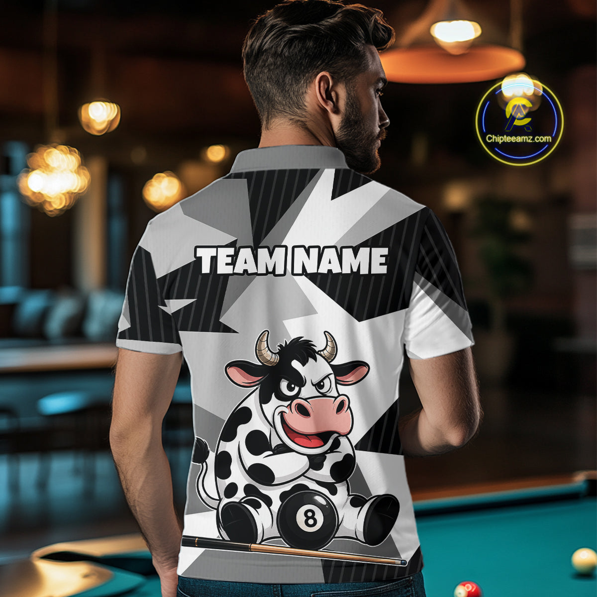 Person wearing a shirt with a cow design and 'TEAM NAME' text in a bar setting