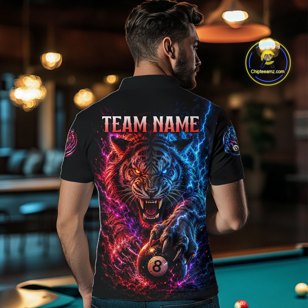 Person wearing a black t-shirt with a colorful tiger design and 'TEAM NAME' text, standing in a bar.