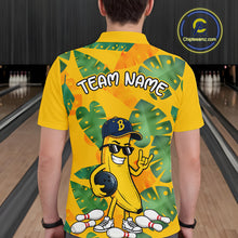 Load image into Gallery viewer, Man in a bowling alley wearing a bright yellow tropical polo shirt with green leaf patterns, custom team name text, and a smiling banana mascot holding a bowling ball.