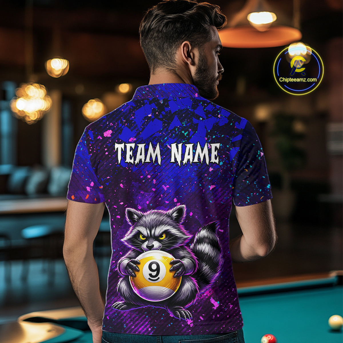 Man wearing a colorful polo shirt with a raccoon and pool ball design, standing in a bar.