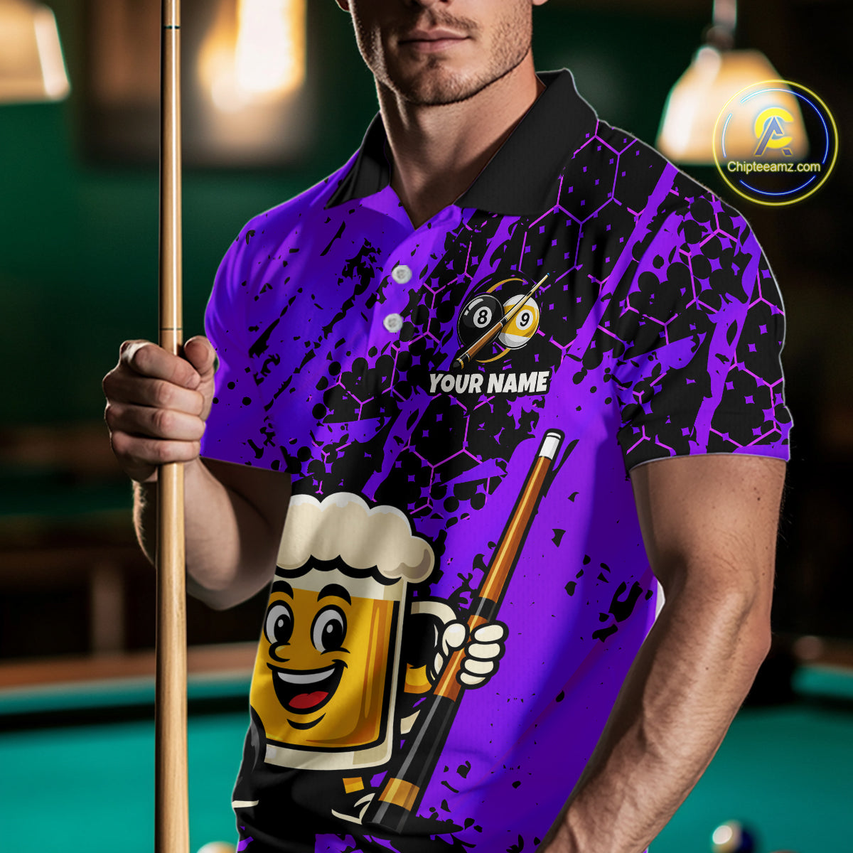 Man wearing a purple funny beer billiard shirt with a pool cue, standing in front of a pool table.