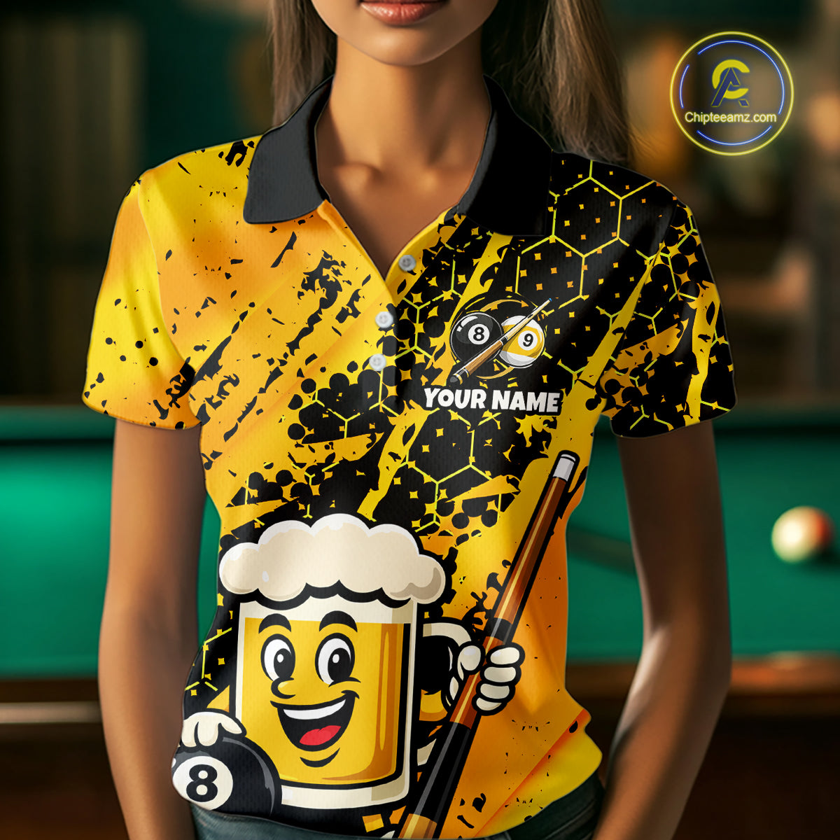 Woman wearing a bright yellow billiards polo with black splatter graphics, custom “YOUR NAME” text, and a smiling beer mug mascot holding a pool cue.