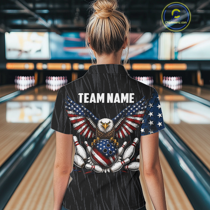 Woman wearing a black patriotic bowling polo shirt featuring distressed American flag graphics, custom team name text, and a bald eagle with spread wings above a flag-themed bowling ball and pins.