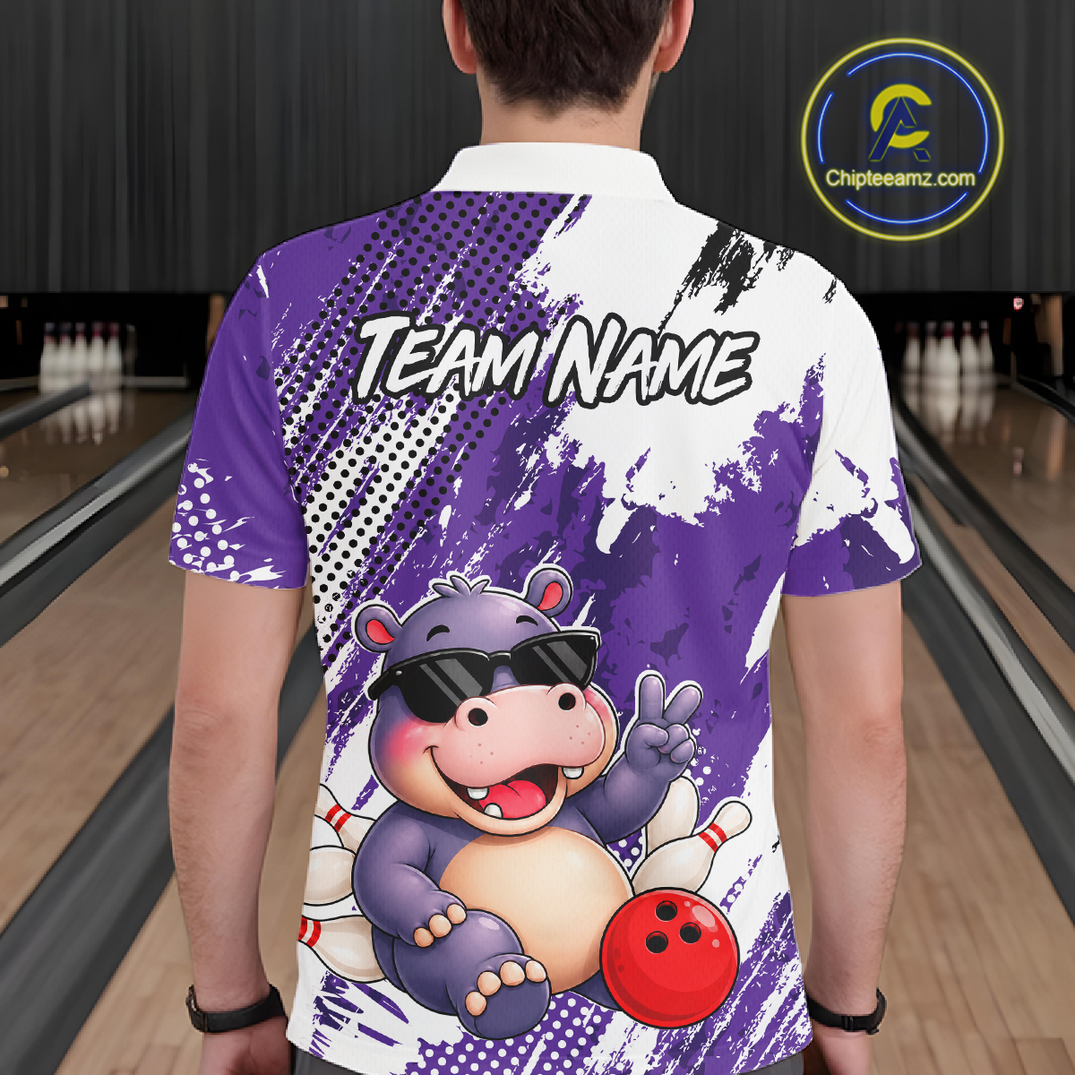 Man wearing a bowling polo shirt featuring smiling hippo mascot in sunglasses, bowling pins, and a red bowling ball