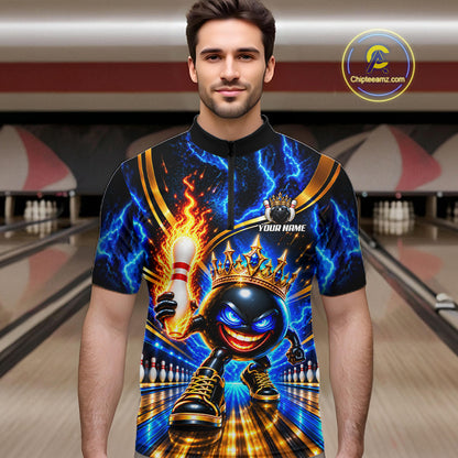 A man wearing a short-sleeve bowling-themed graphic polo shirt with a black, blue, and gold design featuring a cartoon bowling ball character, lightning effects, and a crown. The background shows blurred bowling alley lanes.