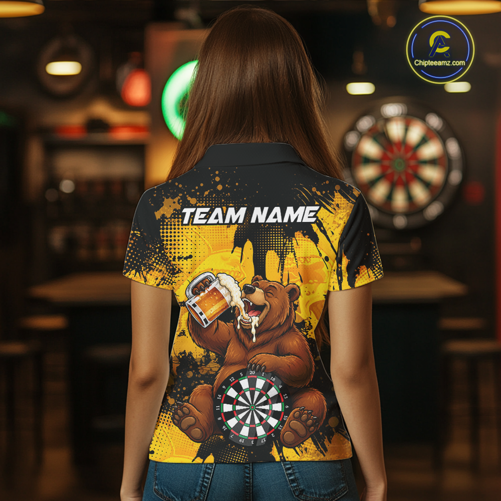 Person wearing a black and yellow darts polo featuring a bear drinking beer, dartboard graphics, and custom team and player name text.