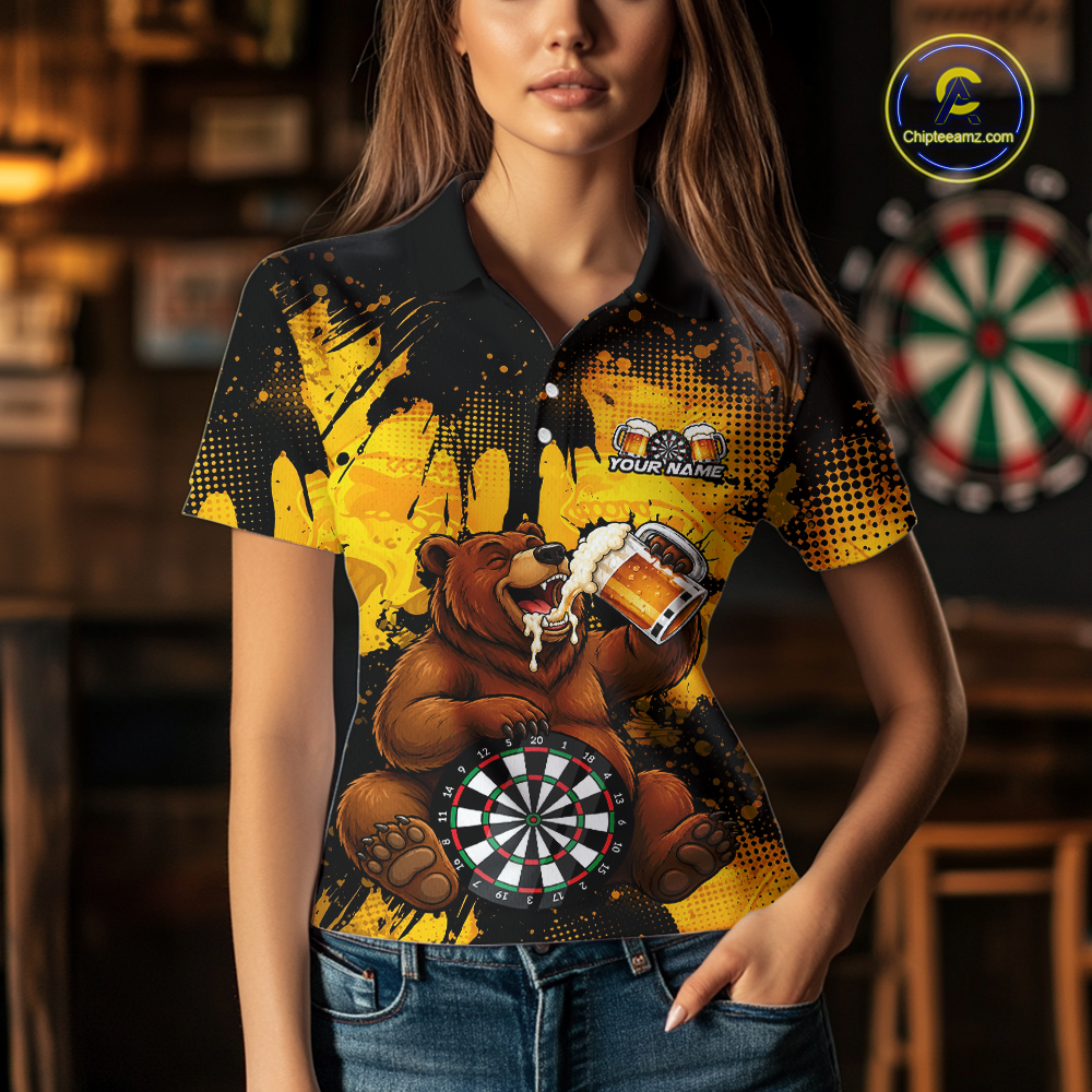 Person wearing a black and yellow darts polo featuring a bear drinking beer, dartboard graphics, and custom team and player name text.