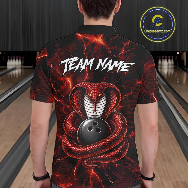 A person viewed from the back wearing a black short-sleeve collared shirt with a bold red and black snake graphic coiled around a bowling ball, plus white lightning effects and the text 'TEAM NAME' across the upper back. The background shows bowling lanes, and a circular 'Chipteeamz.