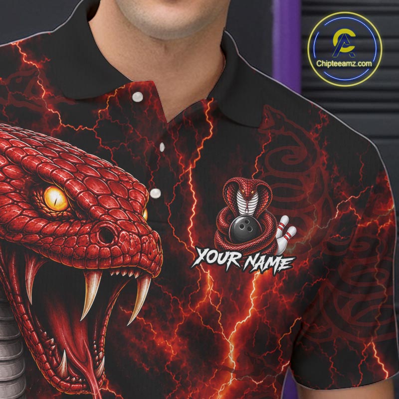 A close-up of a person wearing a black short-sleeve polo shirt with a vivid red and orange snake graphic on the front, lightning effects, and a bowling pin logo with the text 'YOUR NAME'.