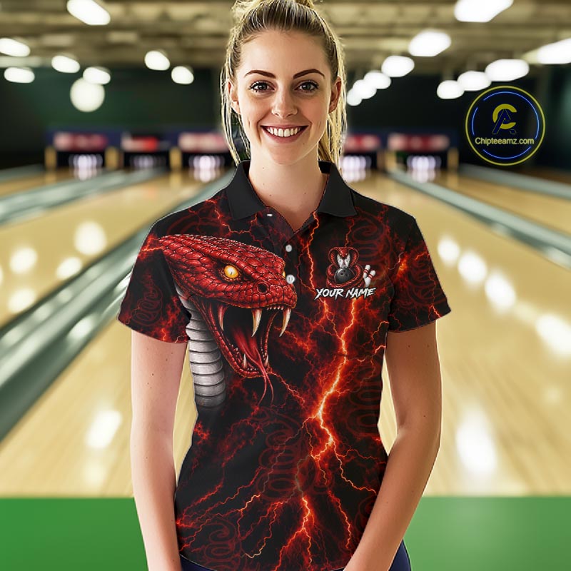 A woman wearing a custom black short-sleeve polo shirt with a red and black lightning snake graphic, standing in a bowling alley. The shirt features a red snake head, lightning bolts, and a customizable text placeholder.