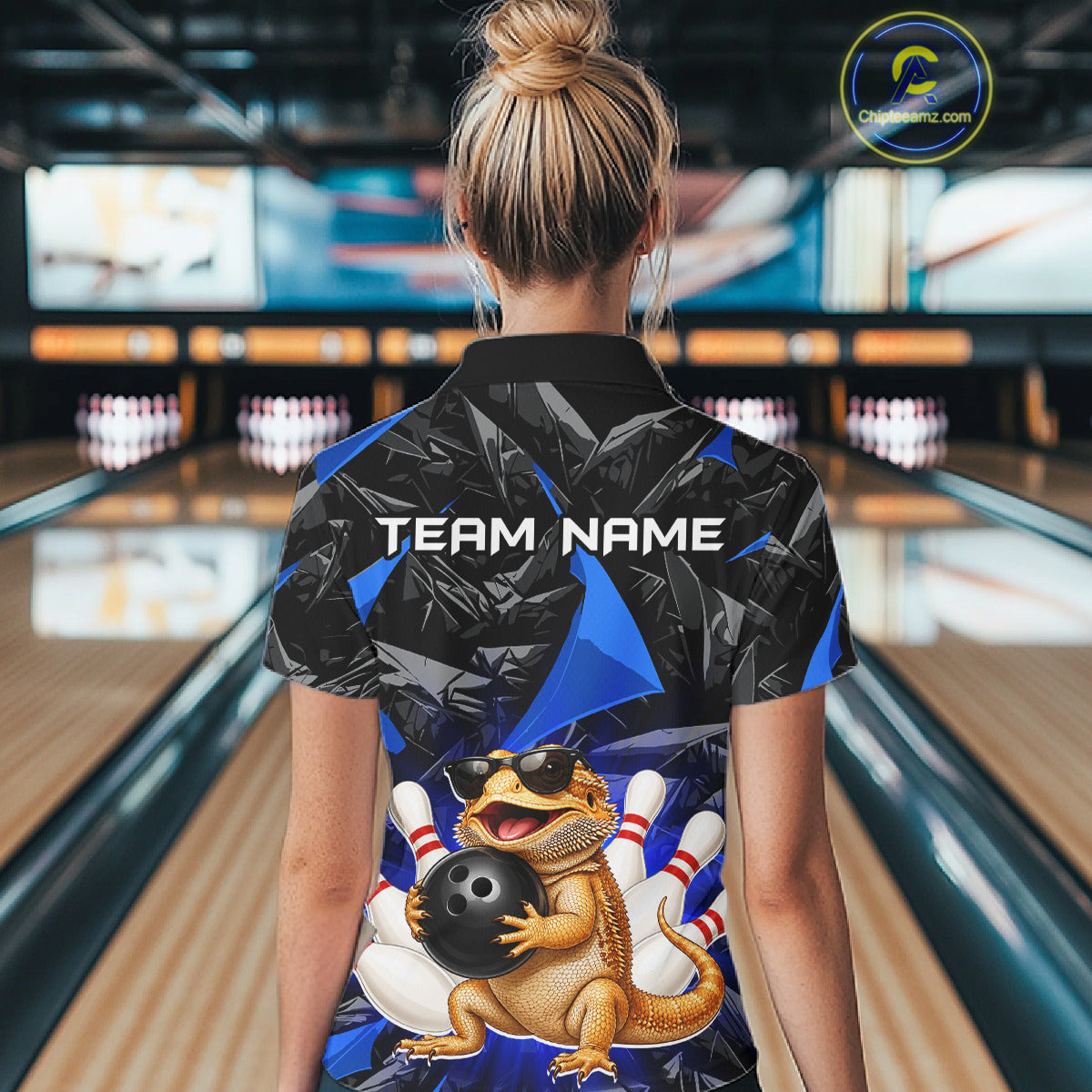 Women’s blue bearded dragon bowling polo shirt, back view on female model in bowling lane 