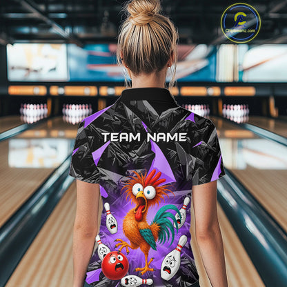 A woman viewed from behind wearing a short-sleeve bowling-themed polo shirt with a colorful cartoon rooster and bowling pins graphic on a purple and black background. Bowling alley lanes are visible in the blurred background.