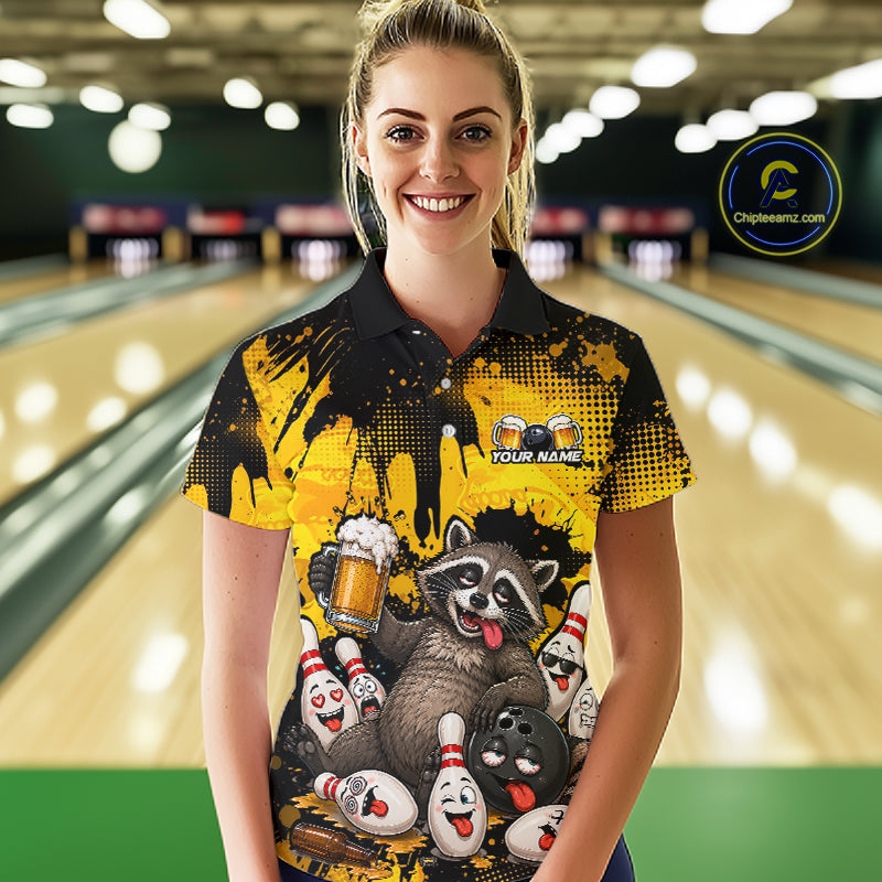 A woman stands in a bowling alley wearing a custom-printed black and yellow polo shirt with a raccoon and bowling pins graphic. The shirt features placeholder text 'YOUR NAME' 