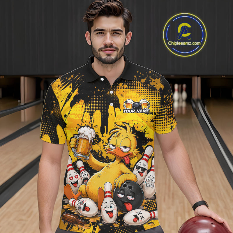 A man wearing a black and yellow bowling-themed graphic polo shirt, standing in a bowling alley holding a bowling ball. The shirt features a cartoon chicken, bowling pins, and a bowling pin head with the text 'YOUR NAME' and a 'Chipteeamz.