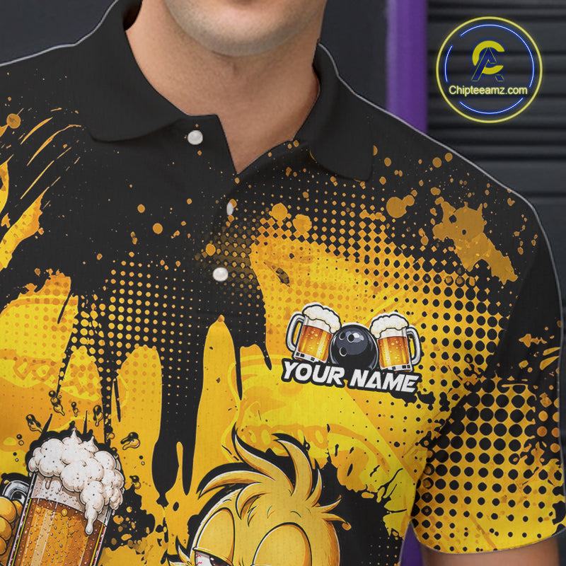 A close-up of a man wearing a black and yellow polo shirt with a custom graphic design featuring beer mugs, a billiard ball, and the text 'YOUR NAME'. The shirt has a black collar and sleeve cuffs, with a bold yellow and black halftone splatter pattern.