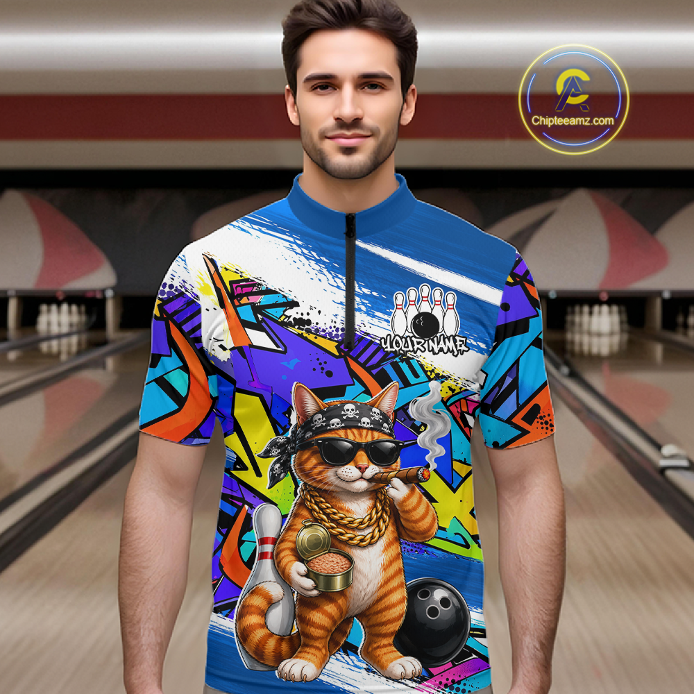 Man wearing a colorful bowling quarter zip shirt with a cat design in a bowling alley.