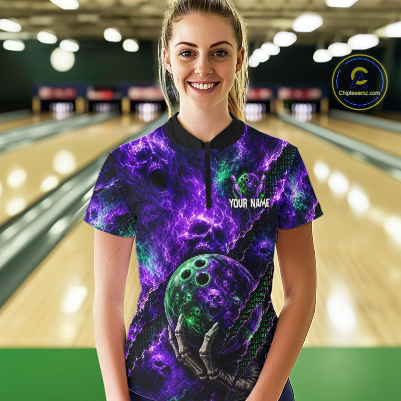 A woman stands in a bowling alley wearing a short-sleeve collared shirt with a purple and green cosmic nebula print, featuring a bowling ball graphic and skeleton hand, with 'YOUR NAME' printed on the chest. 