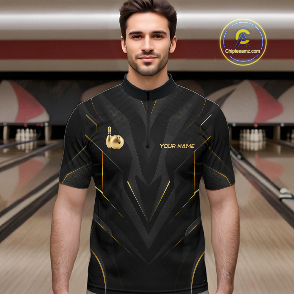 Man wearing a black bowling shirt with gold accents in a bowling alley.