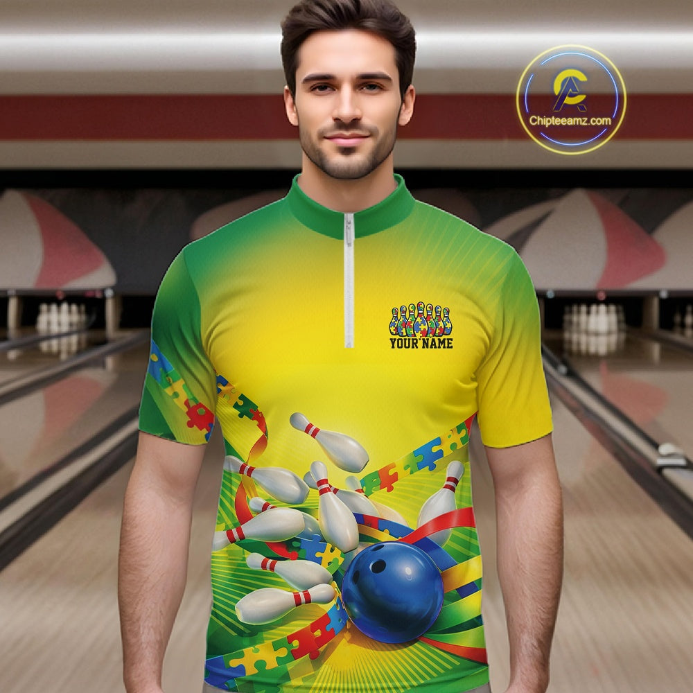 Male model in a bowling lane wearing a green and yellow quarter-zip shirt, autism puzzle bowling ball and pins with vibrant colorful illustration.