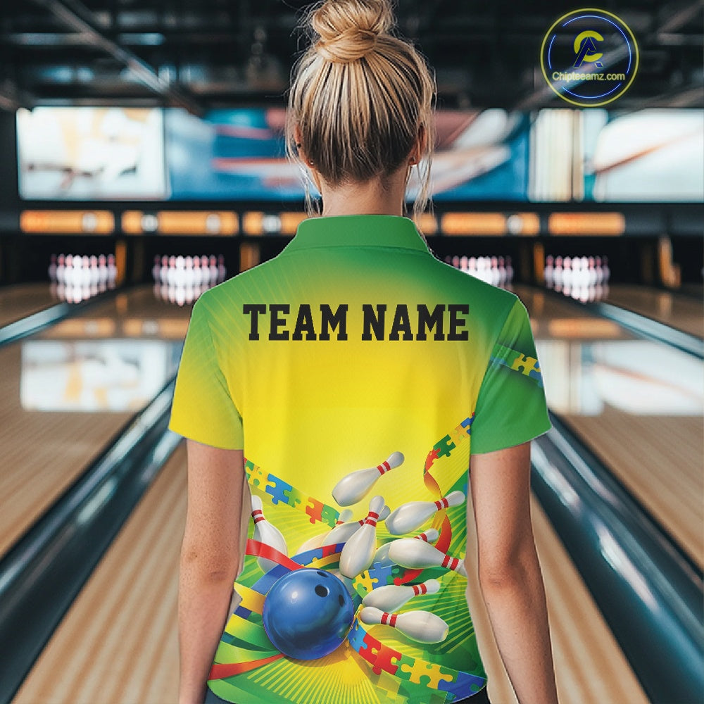 Back view of a female bowler wearing a green and yellow quarter-zip shirt, puzzle bowling ball and pins illustration with colorful autism awareness theme.