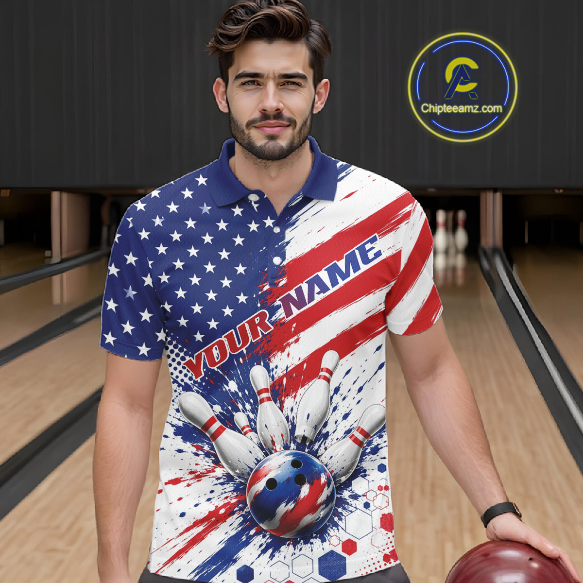 A man wearing a custom bowling-themed polo shirt with a red, white, and blue patriotic design featuring stars, stripes, a bowling ball, and pins. He is standing in a bowling alley holding a bowling ball