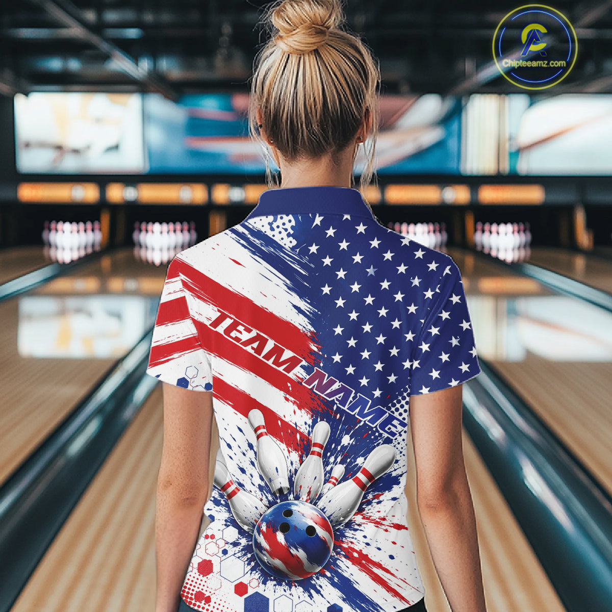 A woman viewed from behind wearing a short-sleeve bowling-themed quarter zip shirt with a red, white, and blue American flag design, pins, and bowling ball graphic.